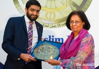 Dr Amina Jindani receives an award in 2018 from Iqbal Nasim, Chief Executive, National Zakat Foundation.