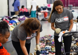 I-CERV volunteers organizing and bagging donated clothing items at the George R. Brown Convention Center. 