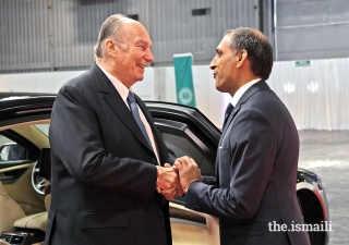 Upon arriving to meet the Jamat, Mawlana Hazar Imam is welcomed by Ismaili Council for France President Shamir Samdjee.