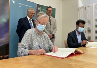 Minister Counsellor of the Norwegian Embassy Sissel Idland (left) and AKF Mozambique National Director Agostinho Mamade (right) signing the grant agreement with the AKDN Diplomatic Representative Nazim Ahmad (left) and the Norwegian Ambassador Haakon Gram-Johannessen (right) looking on.