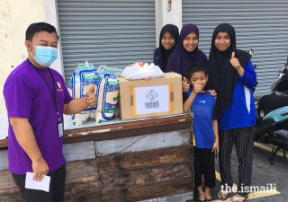 A volunteer delivers a care package to a family as part of the partnership programme between Ismaili CIVIC and Yayasan Chow Kit in Malaysia.