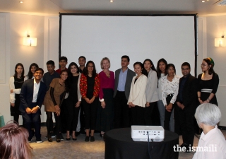 Meredith Preston McGhie, Secretary General of the Global Centre for Pluralism (centre) poses for a group photograph with young members of the Jamat at an institutional dinner in Paris.