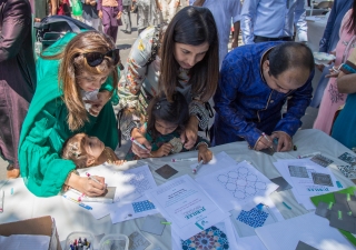 Families come together to design metal tiles for the sculptures on display at the Opening Ceremony.