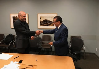 Dr. Mirza Kajani, Chairperson, Aga Khan Health Board for USA, and Greg Szekeres, Deputy Director of UCLA's Center for World Health, exchange documents recording the MOU between Aga Khan Health Service/Aga Khan University and UCLA's School of Medicine.