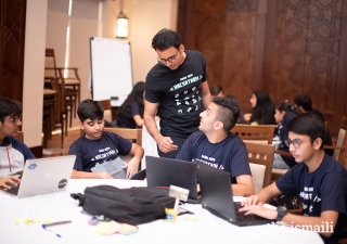 A Hackathon Dubai participant consults with a facilitator to determine if his group is on the right track.