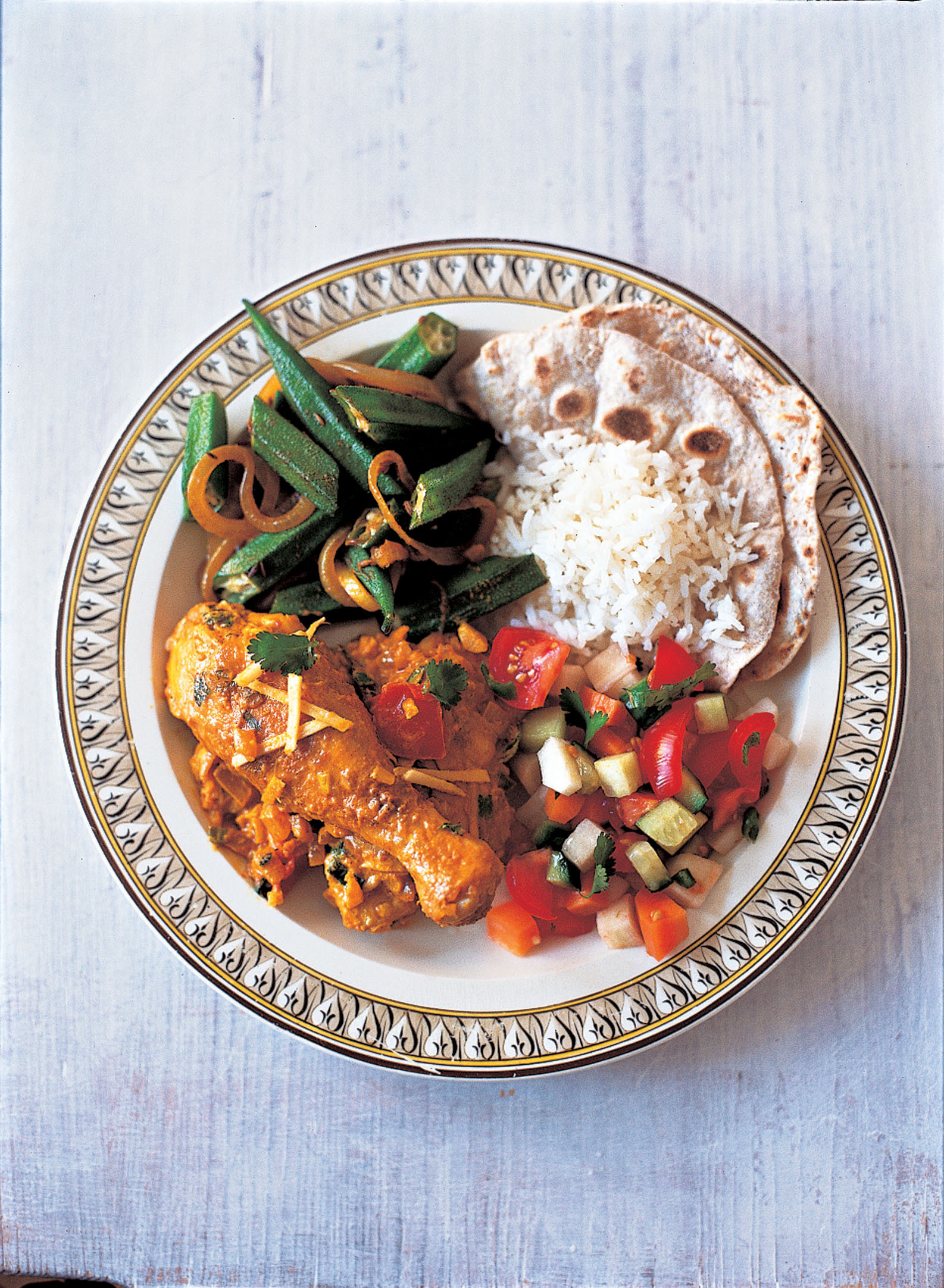 A quarter of the plate is filled with chicken curry, a quarter with vegetable curry, a quarter rice and chapati, and a salad in the last quarter. Photo: Courtesy of Azmina Govindji