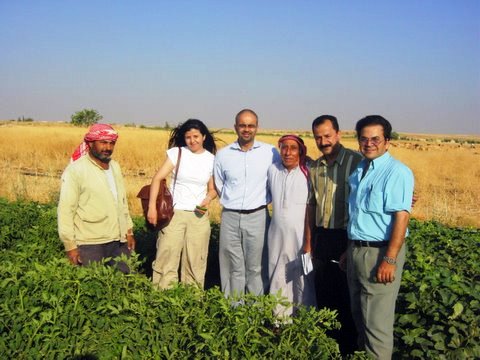 Farmers with Walji and other AKDN staff in a field in Salamieh, Syria. This farm uses drip irrigation to improve crop yield and save water.  The AKDN Water Management Programme has scaled up to include hundreds of farmers since its inception in 2003. Photo: Courtesy Aleem Walji.